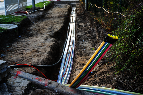 Glasfaser werden in Künette verlegt, Baustelle, Telekommunikation